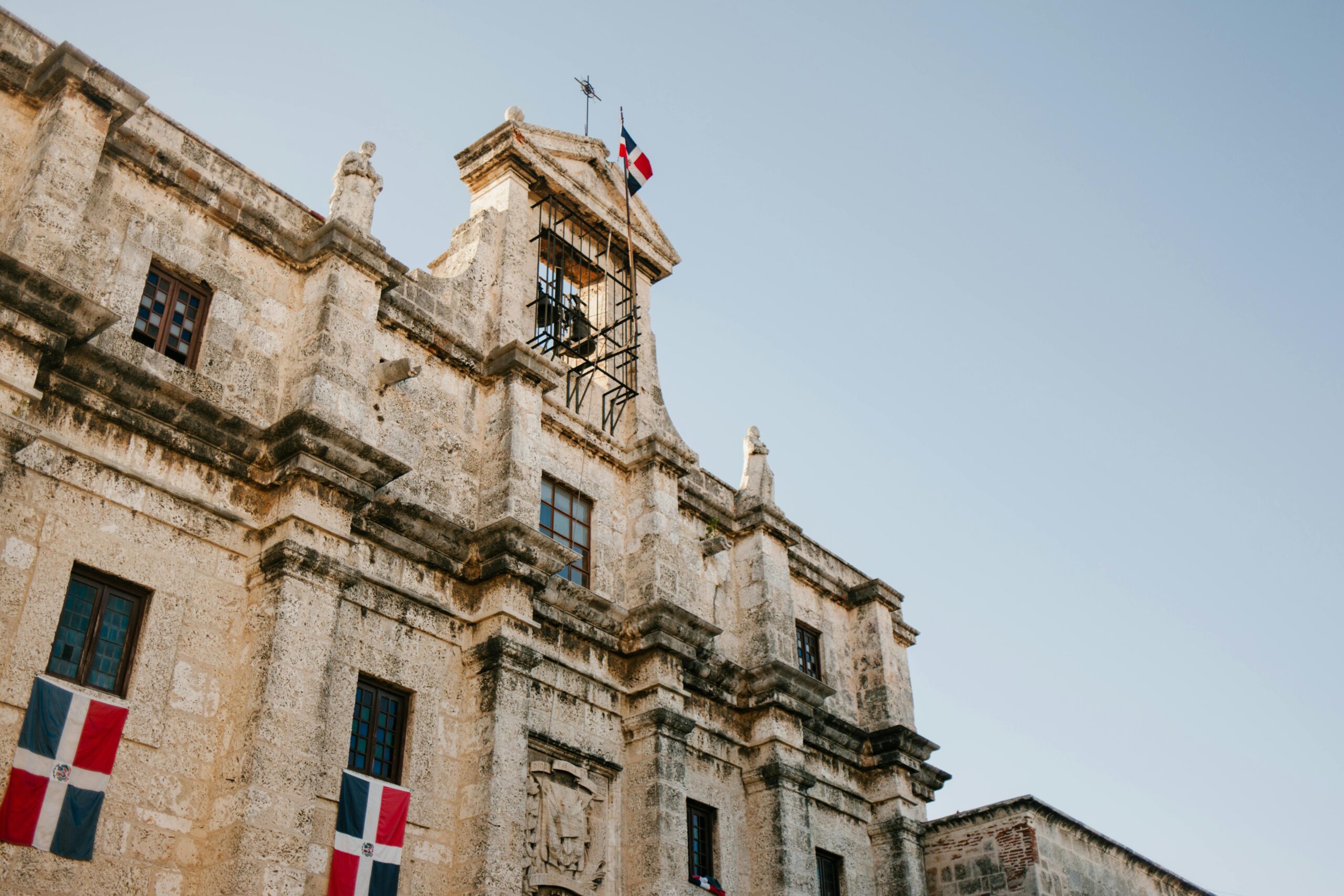 Low angle view of historic colonial architecture with flag in Santo Domingo.